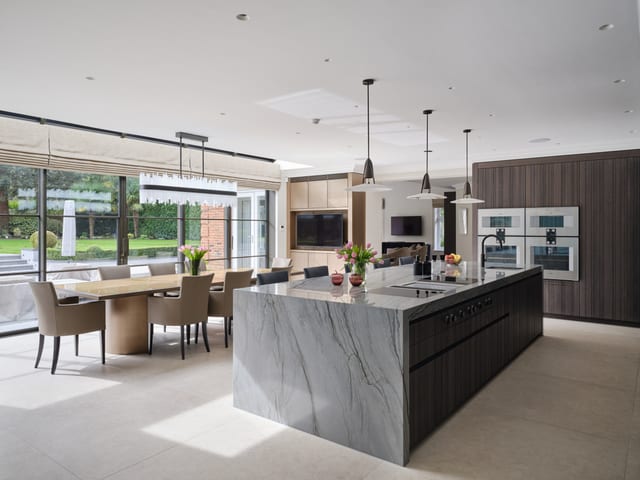 Keston Dark Timber & Gaggenau Kitchen — an angled Platino quartzite island against Leicht Bahia dark timber cabinetry.